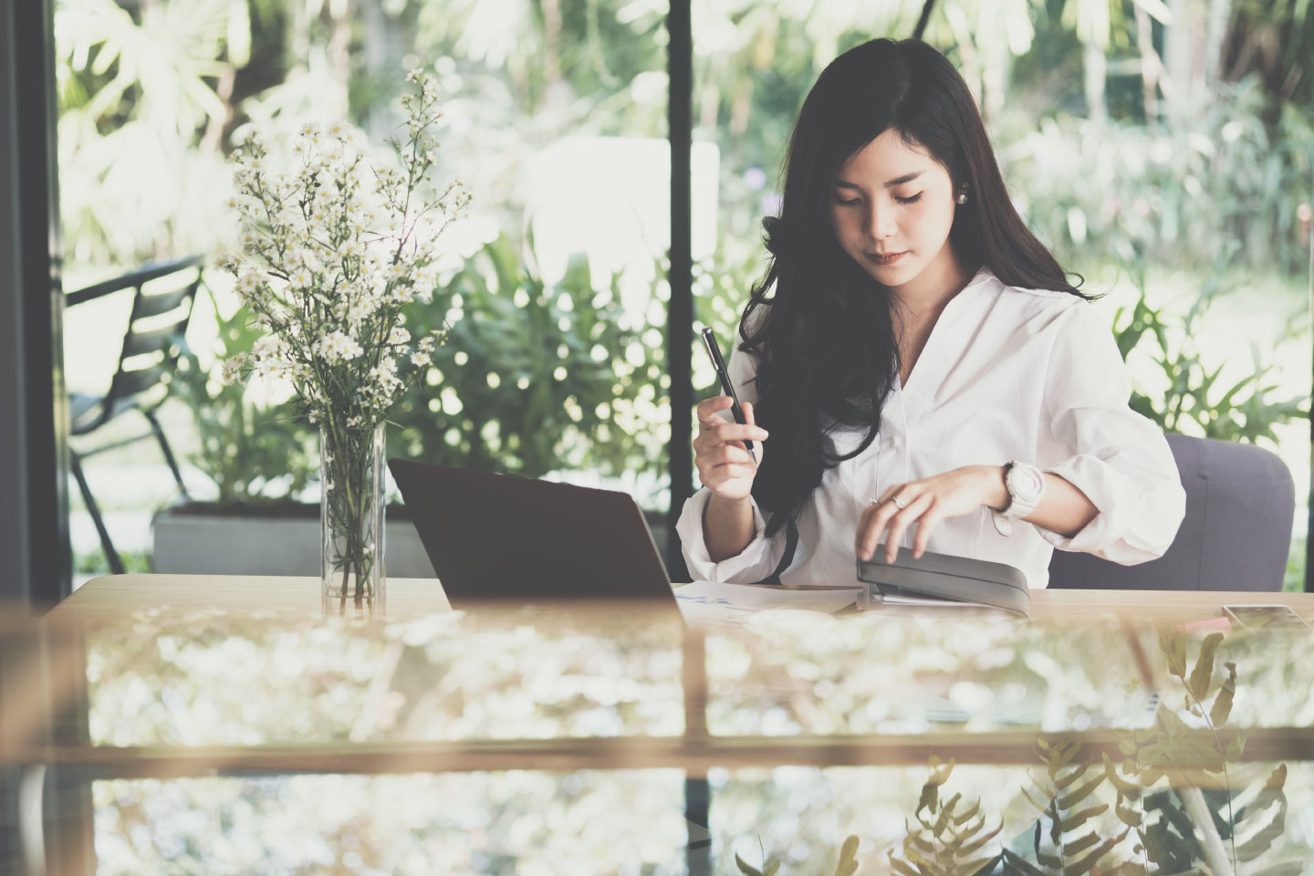 asian-businesswoman-holding-pen-with-notebook-at-workplace_web-size-1