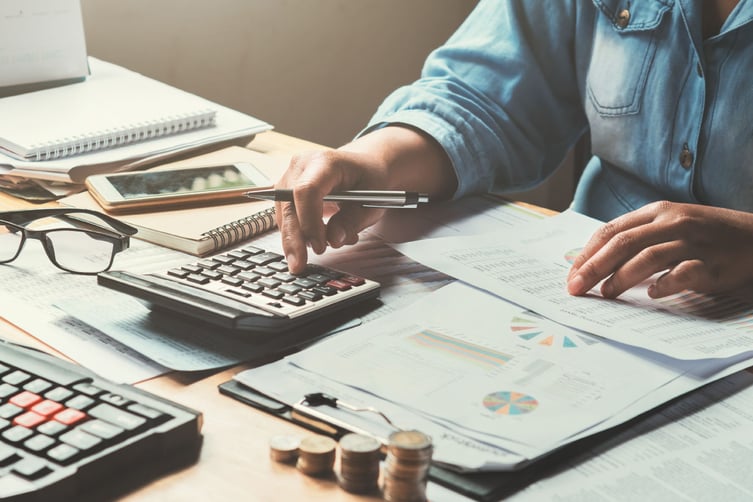 business-woman-using-calculator-to-calculate
