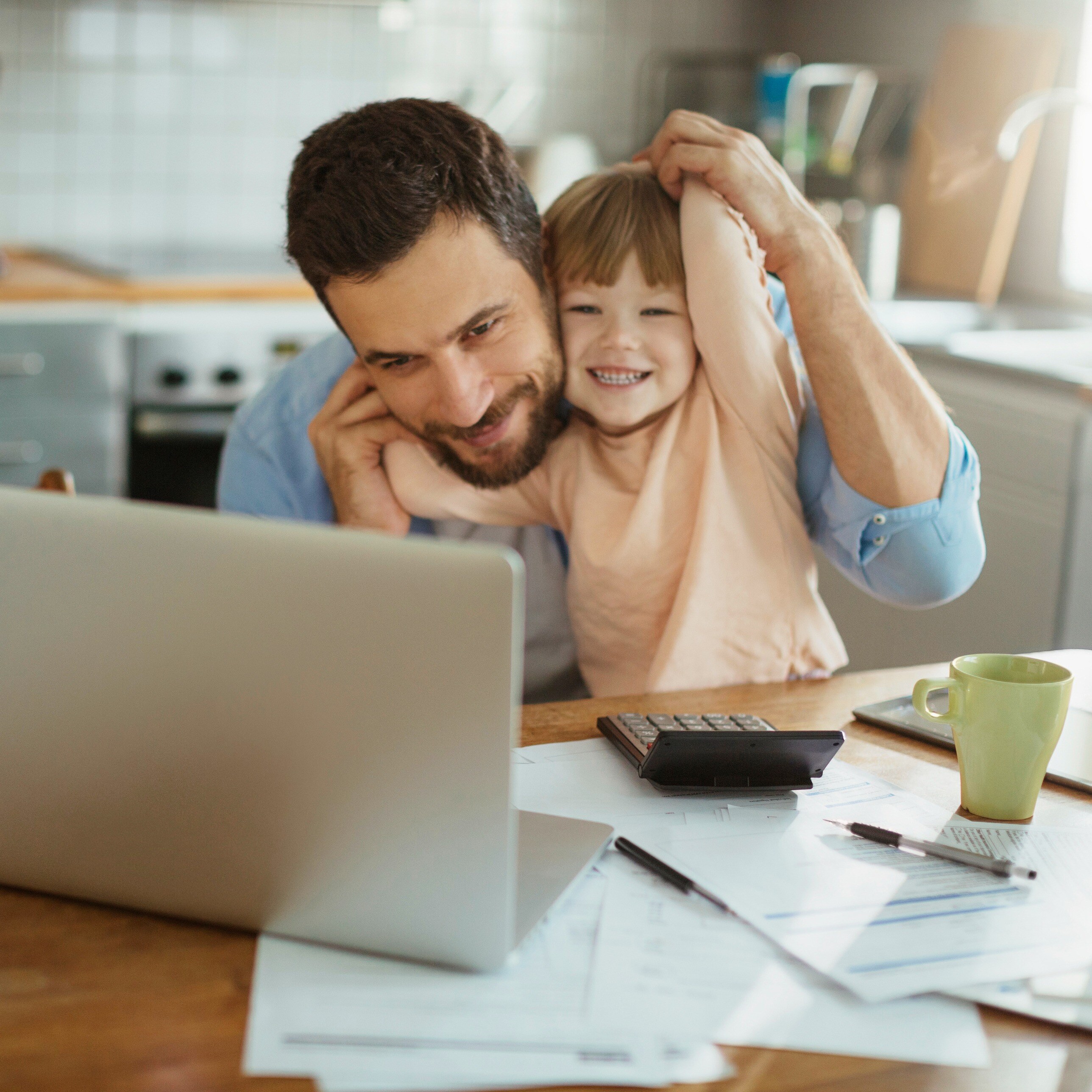 man with his child and a laptop working_iStock-507263878-1